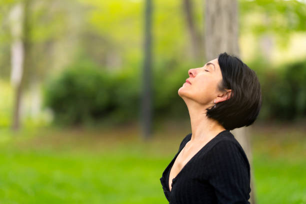 istock Mature woman doing yoga exercise with mat on grass in park 1491705593