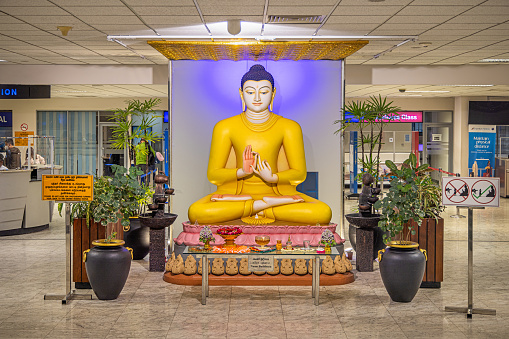 Colombo International Airport, Colombo, Sri Lanka - March 10th 2023:  Large Buddha statue in the departure area in the airport, notice the sign to the right with rules for taking photographs in front of the statue