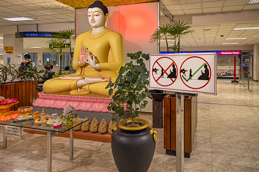 Colombo International Airport, Colombo, Sri Lanka - March 10th 2023:  Sign in front of a large Buddha statue in the departure area of the airport, telling the rules of how to take photographs of people in front of the statue