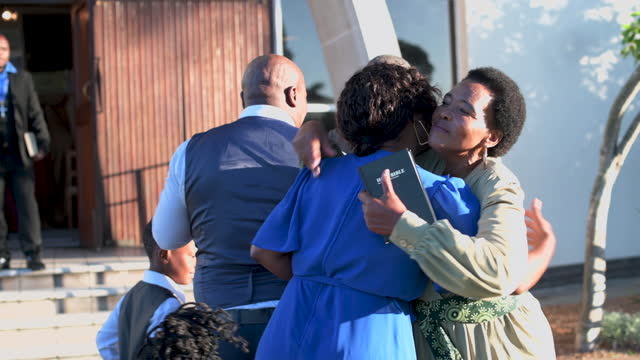 Grandmother hugs family greeting before going into church