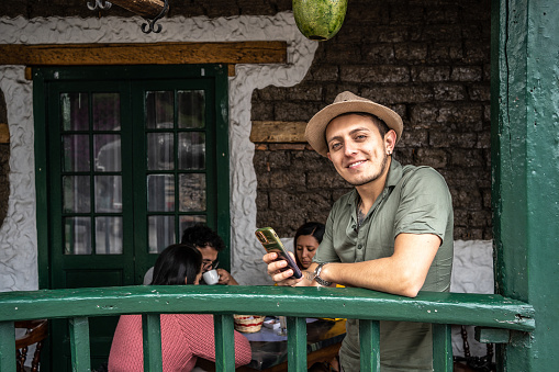 Portrait of a young man using mobile phone at a coffee shop