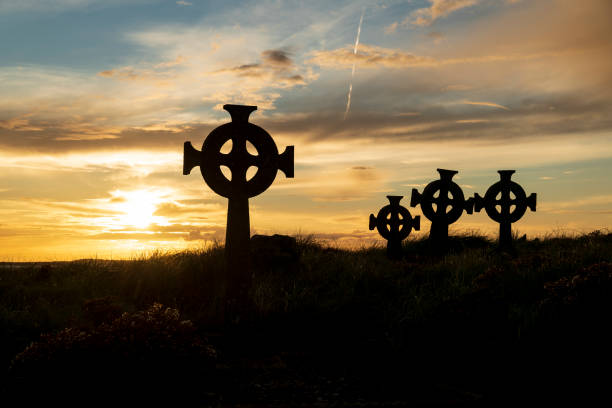 silhouetten von keltischen kreuzgrabsteinen, meeräsche, mayo, irland - celtic cross republic of ireland sunset silhouette stock-fotos und bilder