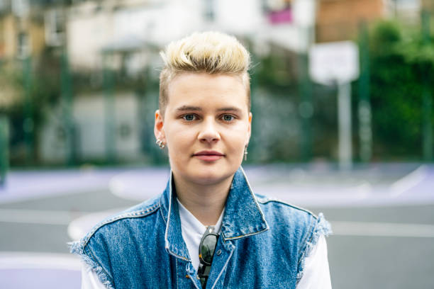Headshot portrait of young white transgender man Front view close up head and shoulder portrait of 20s caucasian transgender male outdoors looking to camera queer man facing camera stock pictures, royalty-free photos & images