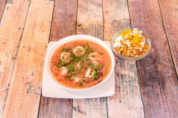 Shrimp ceviche marinated with a lot of coriander, prawns, liquid and as a garnish a court bowl Shrimp ceviche marinated with a lot of coriander, prawns, liquid and as a garnish a court bowl, all on a wooden table raw croaker fish stock pictures, royalty-free photos & images