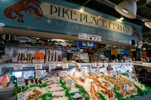 Seattle, WA - June 2022: Pike Place Fish Company an iconic staple of Pike Place Market offers fresh seafood and a show to tourist and locals daily in Seattle.