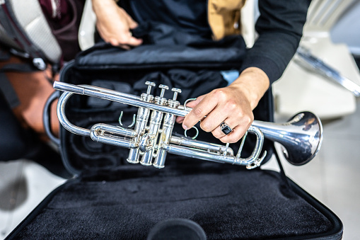 Close-up of a human hand holding a trumpet in the backstage of the music concert