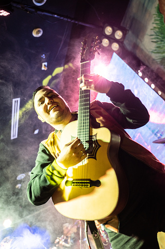 Portrait of a musician man playing guitar in a music concert