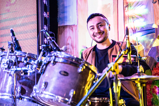 Portrait of a musician man playing drum in a music concert