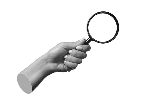 A female hand holding a magnifying glass isolated on a white background.  3d trendy