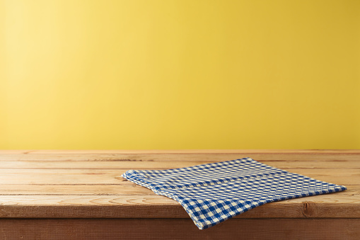 Brazilian Festa Junina summer harvest festival concept. Empty wooden table with tablecloth over yellow background. Mock up for design and product display