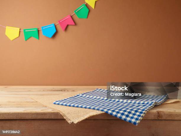 Brazilian Festa Junina Summer Harvest Festival Concept Empty Wooden Table With Tablecloth Over Wall Background Mock Up For Design And Product Display Stock Photo - Download Image Now