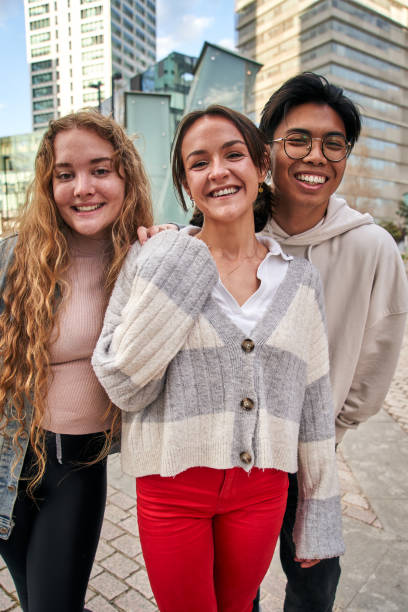 istock Vertical portrait three smiling multiracial young college students. Classmates cheerful and united. 1491734011