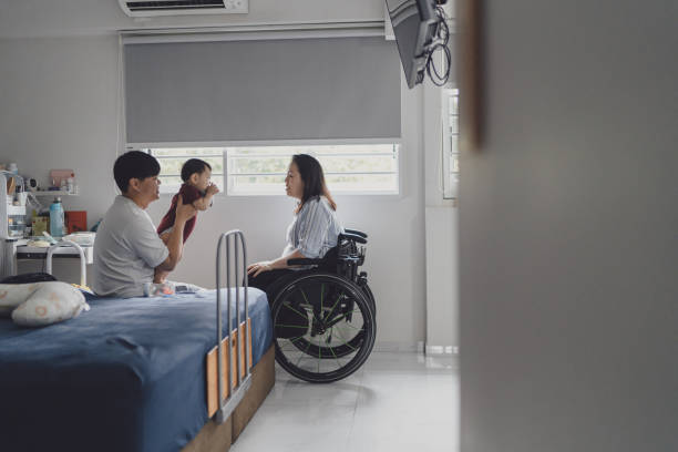 Beyond disability - Disabled Asian Chinese woman with her husband and infant son bonding together stock photo