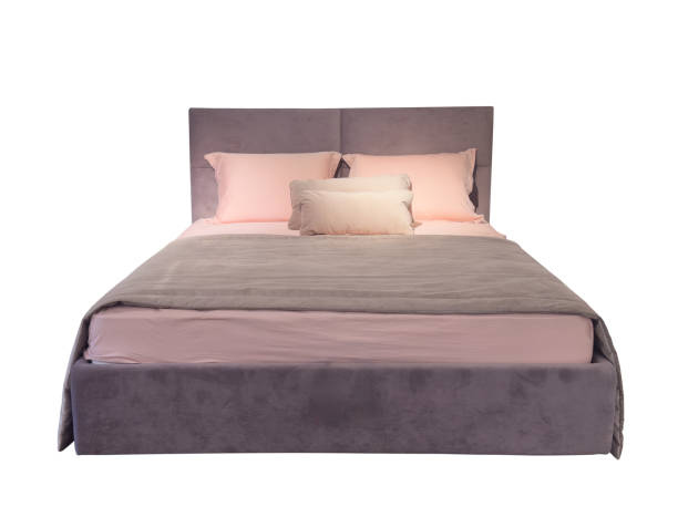 Elegant cozy bed with headboard, blanket and pillows isolated on white background. Bed with a blanket and pillows isolated