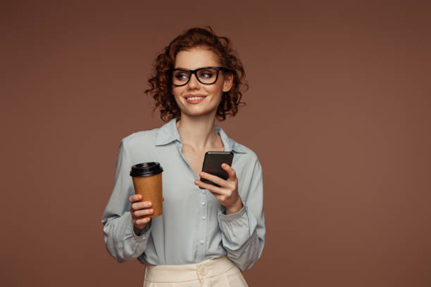 Beautiful emotional woman using phone and drinking coffee