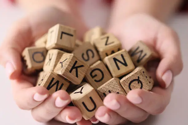 Photo of Wooden cubes with letters on the palms, scrabble game
