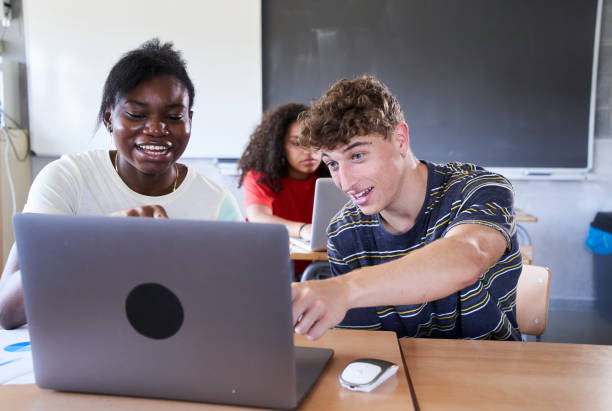 istock Group Of Teenage Students using laptop Collaborating On Project In Class. Education and technology 1491747724