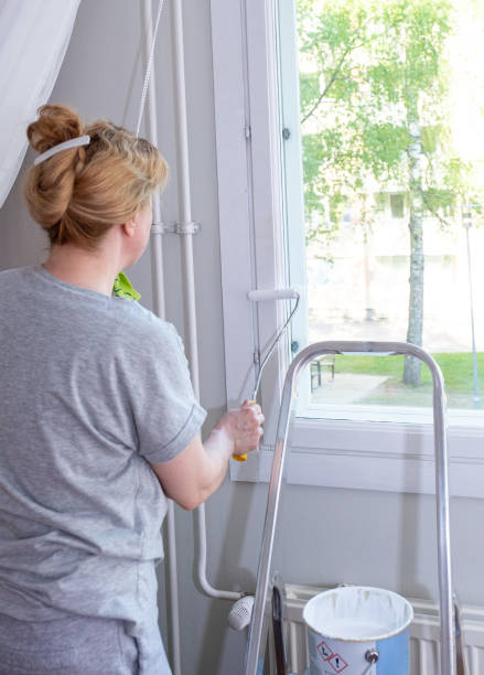 istock A young Caucasian woman paints a window frame with a paint roller. 1491749278