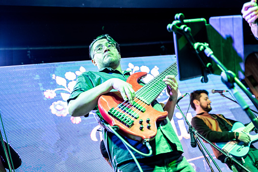 Musician man playing electric bass in a music concert