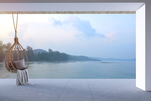 istock Modern contemporary loft style terrace decorated with rattan egg shaped swing chair overlooking sea view 3d render. 1491752502