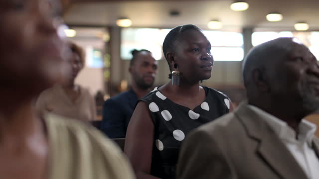 Young woman listening and giving praise in church service