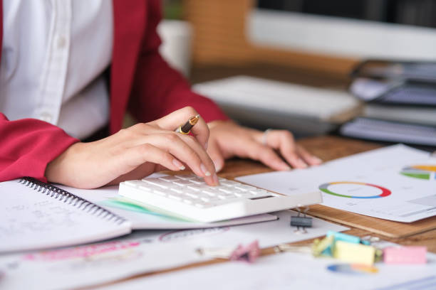 istock Closeup view of financier accountant using calculator for calculating reports and summarizing accounts. 1491760565