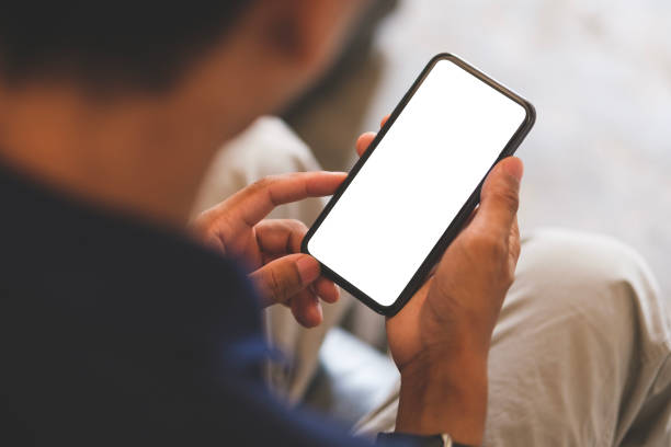 istock Over shoulder close up view, man holding smartphone with mockup white blank display, empty screen for advertise or text message. 1491762880