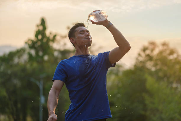 istock Tired athletic man cooling himself after training by squirting water into his face from a bottle. 1491763107