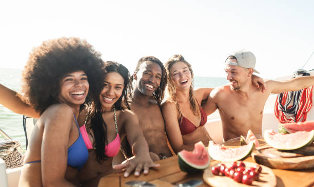 istock Group of smiling friends on boat at sunset enjoying weekend . 1491764587