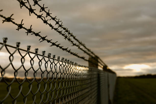 Everybody is imprisoned in this moment, everybody is imprisoned in this moment, there is always a silver lining on the horizon, waiting to bring hope and light into our lives. rusty barbed wire stock pictures, royalty-free photos & images