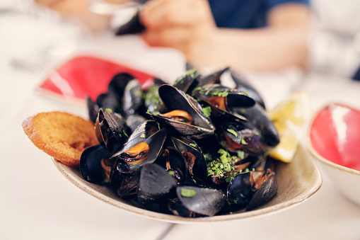 Closeup of a bowl of mussels with garlic sauce\nCanon R5