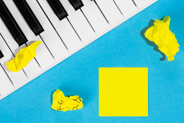 istock Yellow paper sticker and piano on a blue background, top view. 1491777650