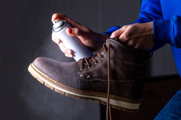 Person is cleaning and spraying agent on men's suede casual boots for protection from moisture and dirt. Shoe shine Person is cleaning and spraying agent on men's suede casual boots for protection from moisture and dirt. Shoe shine shoe polish photos stock pictures, royalty-free photos & images