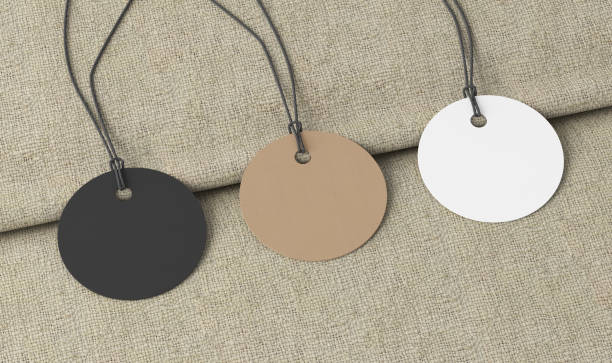 istock White, cardboard, black round tags mockup on fabric background. Side view 1491781587