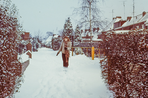 Young woman running in the snow, back in the 1970's