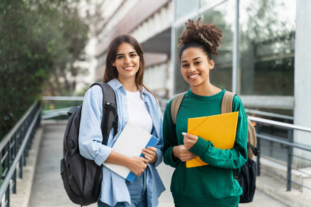 istock Two University Student girls looking at camera smiling outdoors at the college campus 1491790593
