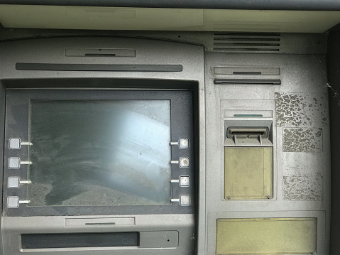 Old, non-working ATM. ATM in the dust. No money.