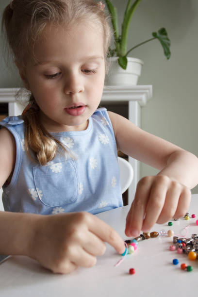 istock Process of making a bracelet from a thread and colored beads, concept of hobby 1491792243