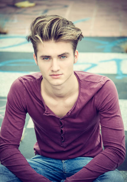Handsome blond young man outdoors, looking away to a side