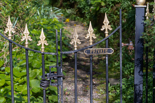 Signage on the locked wrought iron gate to warn passersby of the private area
