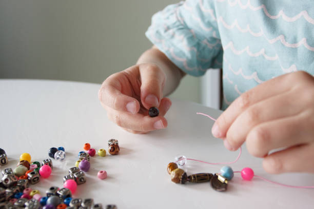istock Process of making a bracelet from a thread and colored beads, concept of hobby 1491793449