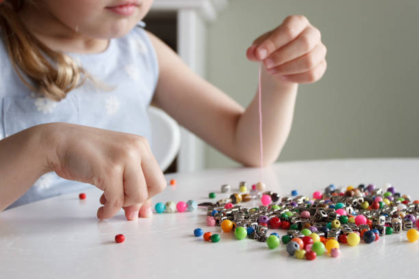 istock Process of making a bracelet from a thread and colored beads, concept of hobby 1491793516