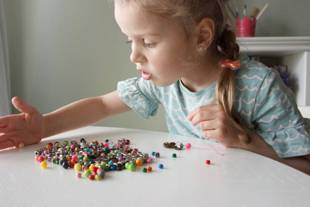 istock Process of making a bracelet from a thread and colored beads, concept of hobby 1491793563