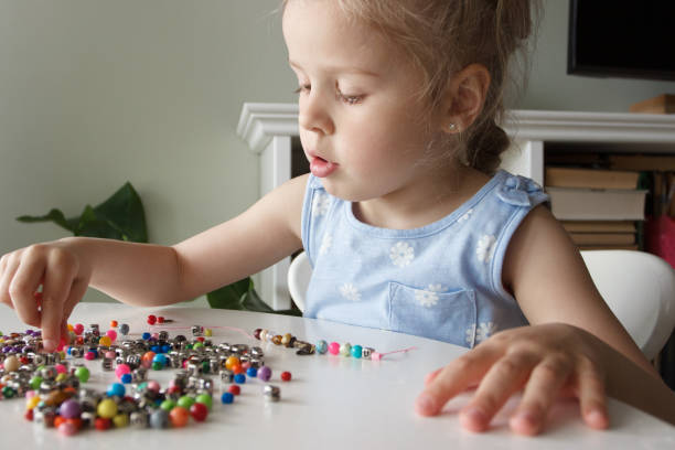 istock Process of making a bracelet from a thread and colored beads, concept of hobby 1491793858