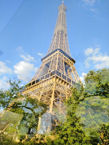 Eiffel Tower mirrored in a street window on a sunny day in Paris, France