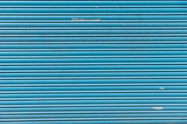 istock detail of a worn blue metal shutter, textured background 1491800478