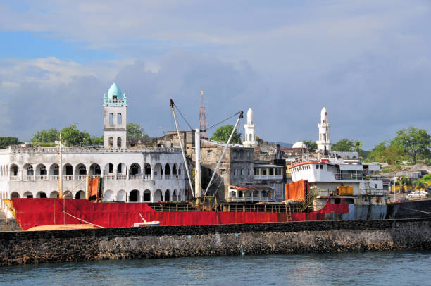 Rusty old freighter in the dhow port and the old Friday Mosque, Moroni, Grande Comore, Comoros Islands Moroni, Grande Comore / Ngazidja, Comoros islands: listing old bulk carrier ship at the dhow port (Port aux Boutres) and the Old Friday Mosque on Badjanani Square (left) with the twin minarets of the new Friday Mosque on the right. comoros stock pictures, royalty-free photos & images