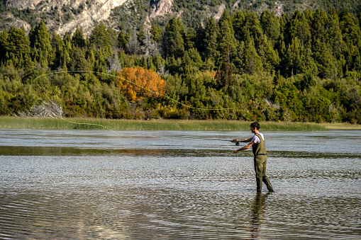 Young man practices sport fly fishing in the Rio Grande or Futaleufú, in Chubut, Patagonia Argentina.