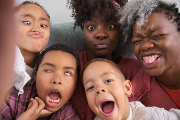 istock African horizontal extended family taking a selfie making funny faces at home. 1491816453