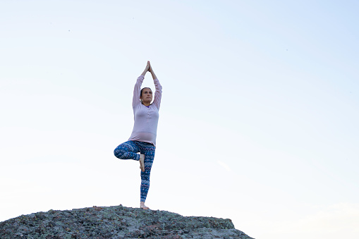 Pregnant woman doing exercises at high viewpoint on Belogradchik rocks.